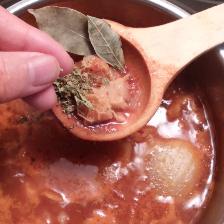 adding herbs to soup
