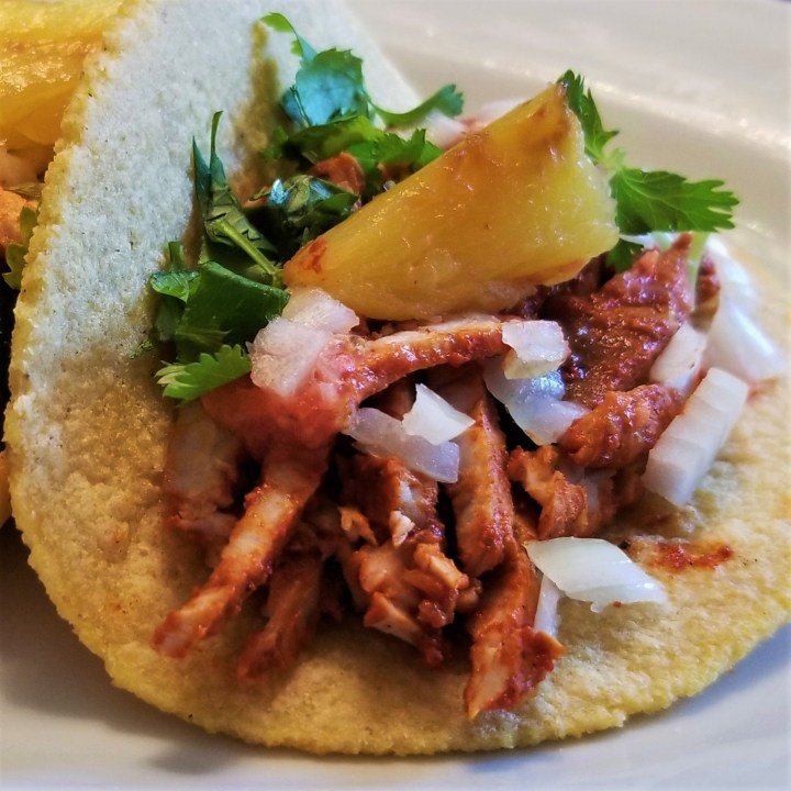 016 on homemade tortilla topped with cilantro, onion and pineapple